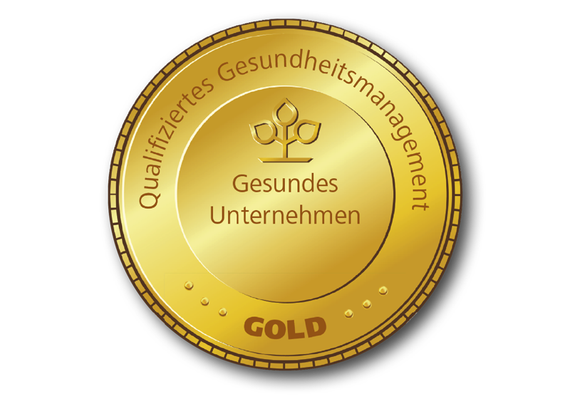 Goldfarbendes, rundes Siegel auf dem „Gesundes Unternehmen, Qualifiziertes Gesundheitsmanagement“ und „Gold“ steht.