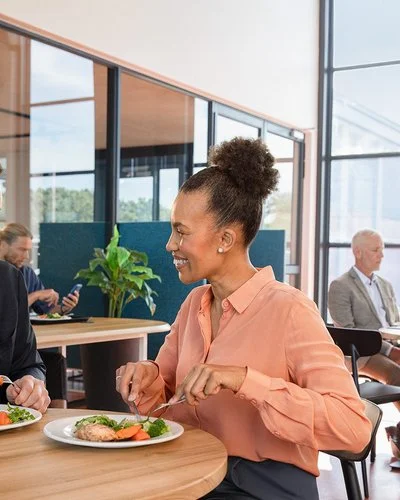 Ein Mann und eine Frau sitzen in einer Kantine am Tisch  und essen