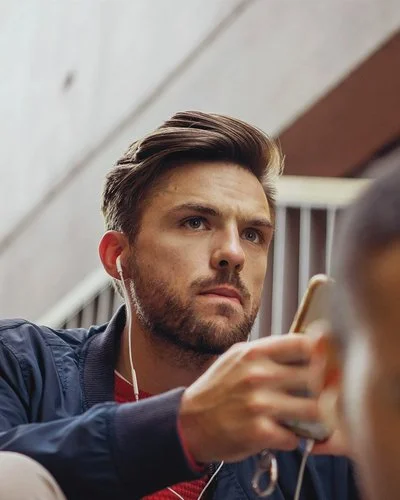 Ein Mann schaut nachdenklich auf sein Smartphone.
