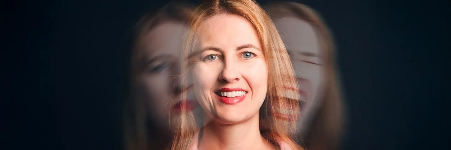 Eine Frau lacht in die Kamera. Auf ihren Schultern ihr Gesicht, wie es einmal traurig schaut und einmal schreit.