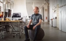 Ein Mann in einem Büro auf einem Sitzball