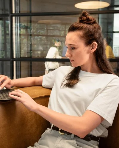 Eine Frau arbeitet konzentriert am Laptop in einem offenen Coworking-Space.