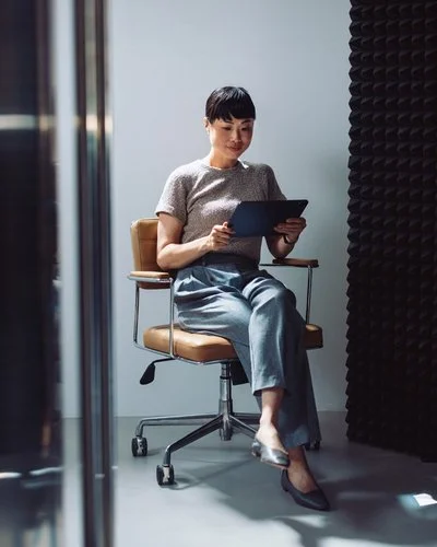 Frau auf Bürodrehstuhl mit digitalem Gerät