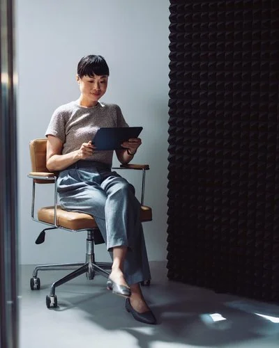 Frau auf Bürodrehstuhl mit digitalem Gerät