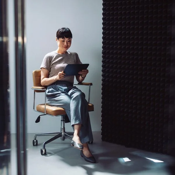 Frau auf Bürodrehstuhl mit digitalem Gerät