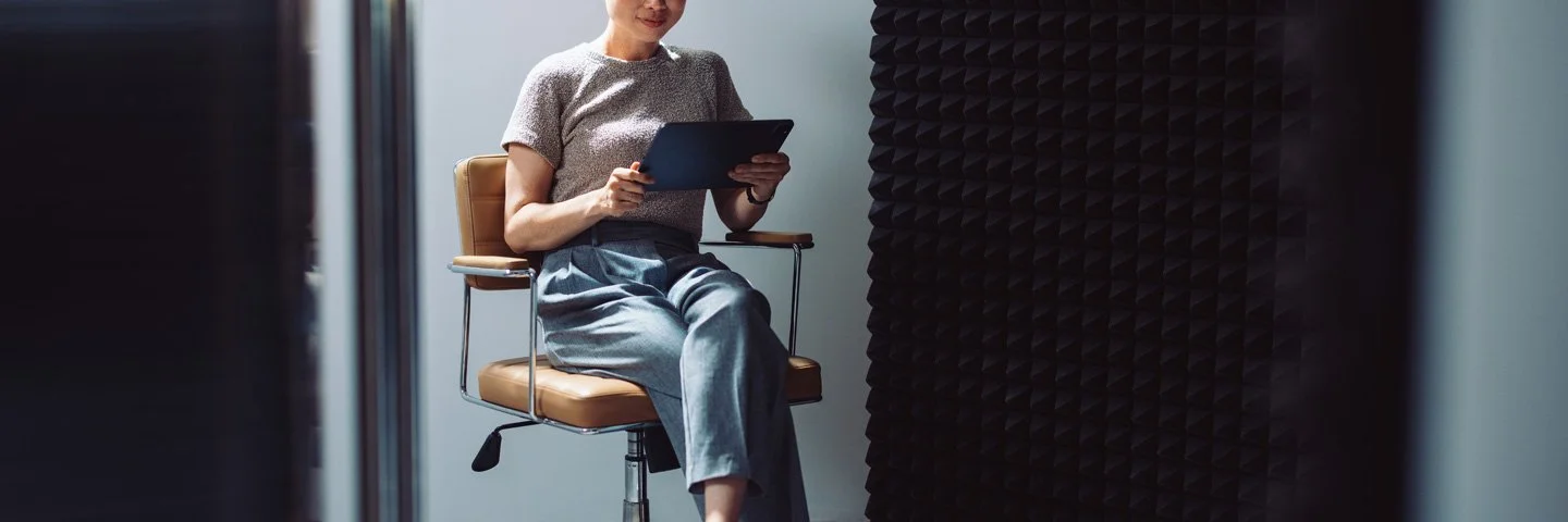 Frau auf Bürodrehstuhl mit digitalem Gerät