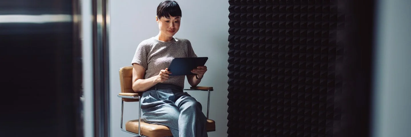 Frau auf Bürodrehstuhl mit digitalem Gerät