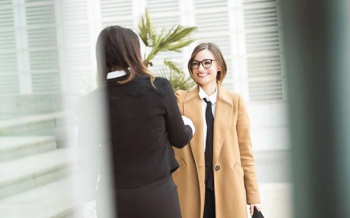 Zwei Frauen begrüßen sich mit einem Händedruck
