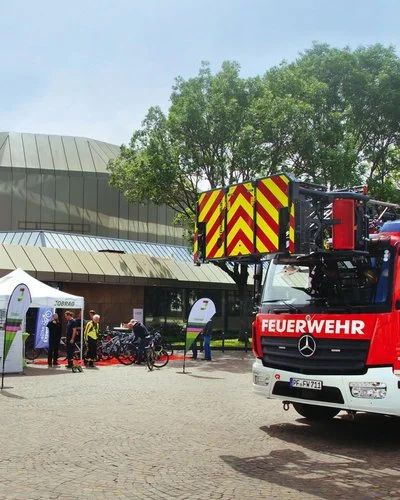 Ein Feuerwehrauto und ein AOK-Stand vor einem Gebäude