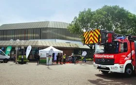 Ein Feuerwehrauto und ein AOK-Stand vor einem Gebäude