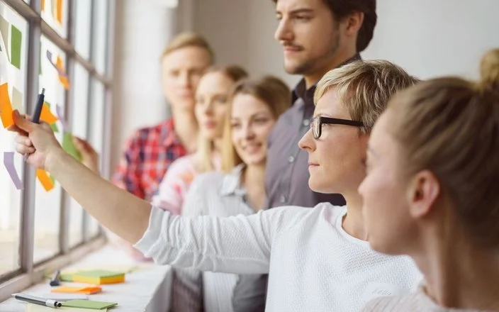 Junge Mitarbeitende im Gespräch während eines Workshops – Symbol für Gesundheitsförderung und Teamkultur