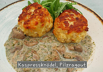 Auf einem Teller ist ein Gericht aus Kaspressknödeln und Pilzragout angerichtet