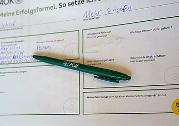 TST Career Starter: ein Fragebogen zum Workshop mit einem grünen AOK-Kugelschreiber