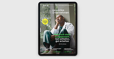 gesundes unternehmen Ausgabe 4-2026: Eine Person im Arztkittel ist sichtbar, sie macht Pause und schließt die Augen dabei.