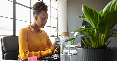 Neues in den digitalen Meldeverfahren: Frau sitzt im Büro vor einem Bildschirm