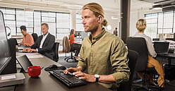 SV-Informationen für Arbeitgeber: Mann am Computer im Großraumbüro