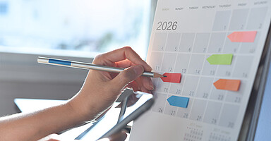 Neues zum Jahreswechsel: Hand markiert mit Bleistift auf Kalenderblatt Januar 2026