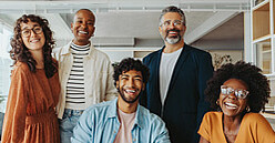 Ein vielfältiges Team von Mitarbeitern unterschiedlicher Nationalitäten arbeitet zusammen in einem modernen Büro.