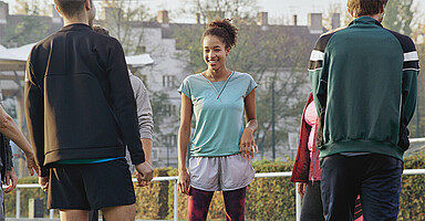 BGF und Nudging für Azubis: Junge Menschen beim Outdoor-Training auf einem Sportplatz