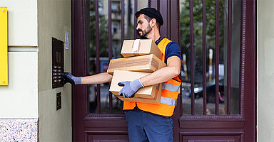 Basisarbeitende wertschätzen: Paketlieferant klingelt an einem Wohnhaus