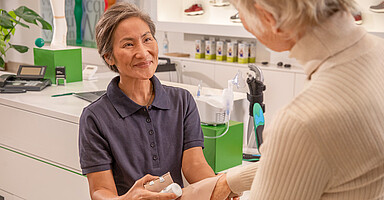 Beschäftigung und Rente: eine ältere medizinische Fachkraft legt einen Verband an Beschäftigung und Rente: eine ältere medizinische Fachkraft legt einen Verband an