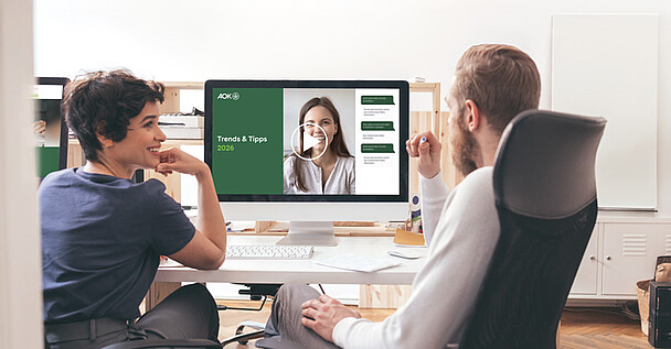 Trends & Tipps 2026 – Neues in der Sozialversicherung: zwei Personen in einem Büro schauen sich ein Online-Seminar an .