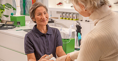 Beschäftigung und Rente: Eine ältere medizinische Fachkraft legt einen Verband an Beschäftigung und Rente: Eine ältere medizinische Fachkraft legt einen Verband an