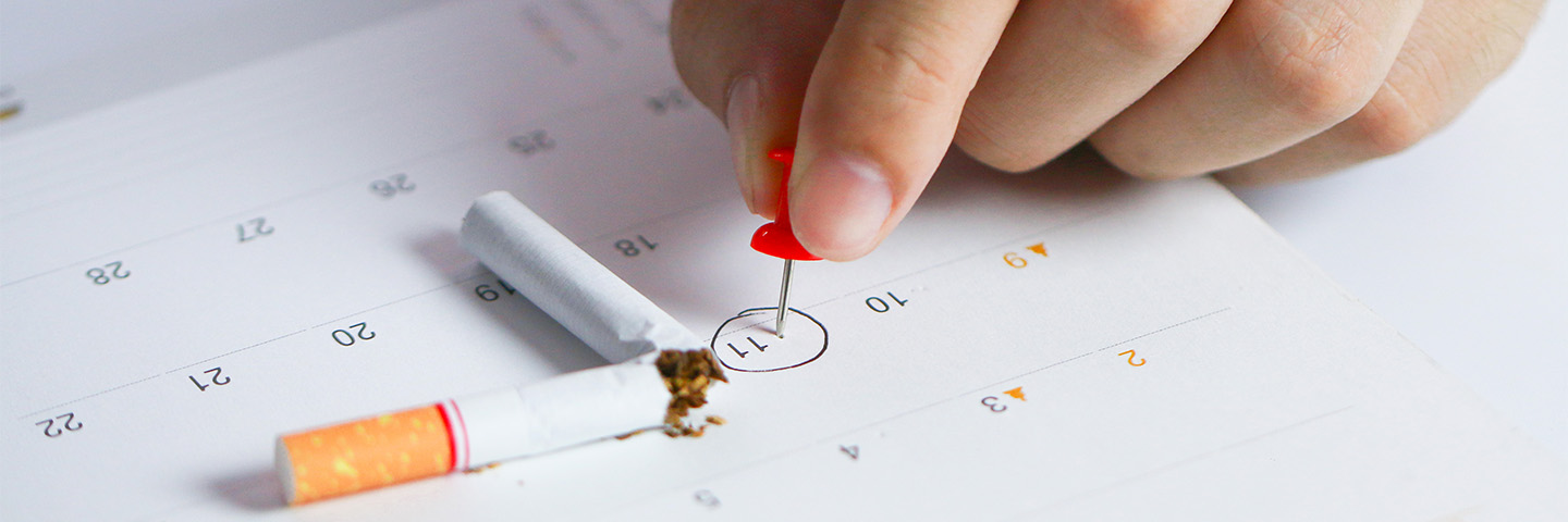 Auf einem Kalender liegt eine durchgebrochene Zigarette und ein Datum ist eingekreist. 