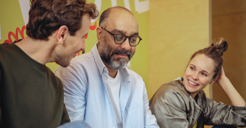 Diversität im Unternehmen: Drei Teammitglieder im freundlichen Austausch