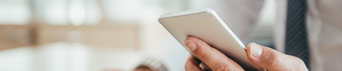 Immer informiert mit den aktuellsten Meldungen der AOK Ein Arbeitnehmer hält ein Handy