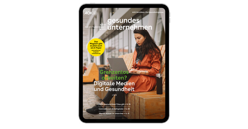 gesundes unternehmen Ausgabe 4-2025: Frau arbeitet am Laptop auf einer öffentlichen Bank