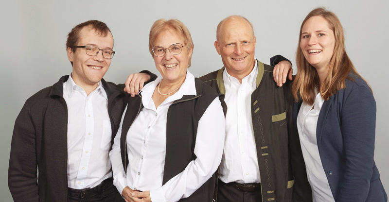 Eine Gruppe von 4 Personen mit 2 Frauen und 2 Männern unterschiedlichen Alters und Geschlecht.