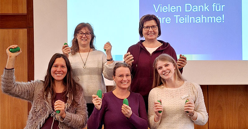 Frauengesundheitstag Auf dem Bild sind fünf fröhliche Frauen vor einer Leinwand zu sehen.