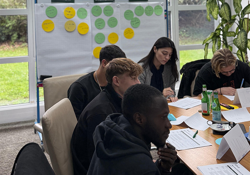 TST Career Starter: eine kleine Gruppe aus Männern und Frauen bearbeiten einen Fragebogen zum Workshop