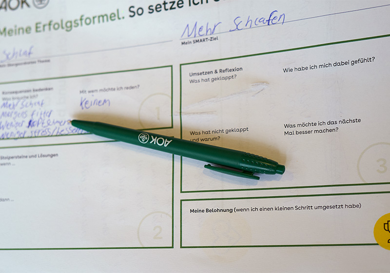 TST Career Starter: ein Fragebogen zum Workshop mit einem grünen AOK-Kugelschreiber
