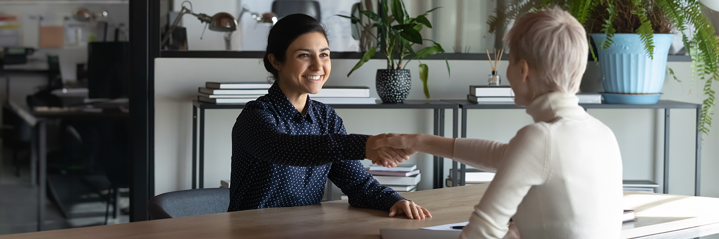 Finanzielle Projektförderung: Zwei Frauen besiegeln mit einem Handschlag eine Übereinkunft