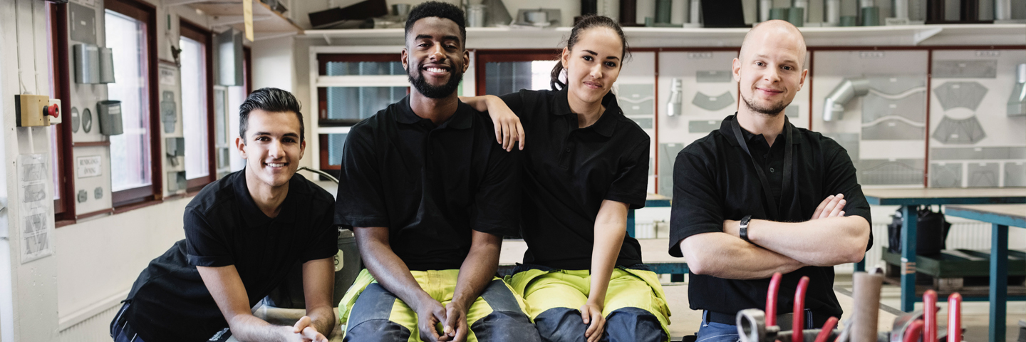 Gesund in den Beruf starten Das Bild zeigt 4 Auszubildende in einer Werkstatt.
