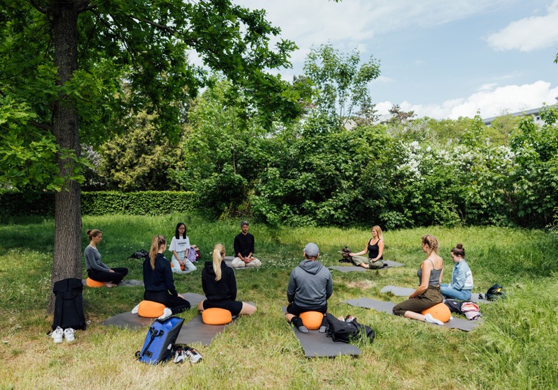 Projekt ABiK der Uni Leipzig: eine Gruppe aus Männern und Frauen, die auf einer Wiese im Kreis sitzt und meditiert Projekt ABiK der Uni Leipzig: eine Gruppe aus Männern und Frauen, die auf einer Wiese im Kreis sitzt und meditiert