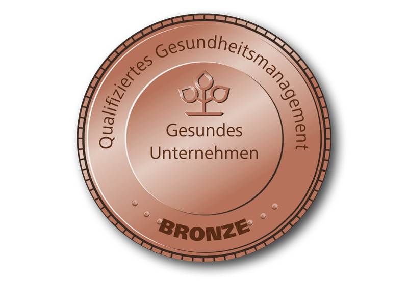 Bronzefarbendes, rundes Siegel auf dem „Gesundes Unternehmen, Qualifiziertes Gesundheitsmanagement“ und „Bronze“ steht.