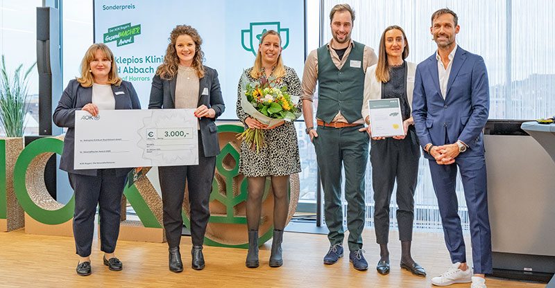 Preisverleihung GesundMacher Award 2025: Eine Gruppe von Personen präsentiert einen Gewinnerscheck