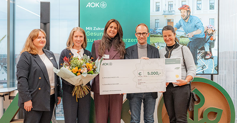 Preisverleihung „GesundMacher Award 2025“: Eine Gruppe von Personen präsentiert einen Gewinnerscheck Preisverleihung „GesundMacher Award 2025“: Eine Gruppe von Personen präsentiert einen Gewinnerscheck