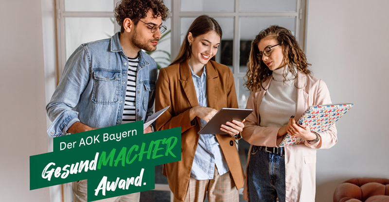 Der AOK Bayern GesundMacher Award: Eine Gruppe junger Menschen schaut auf ein Tablet Der AOK Bayern GesundMacher Award: Eine Gruppe junger Menschen schaut auf ein Tablet