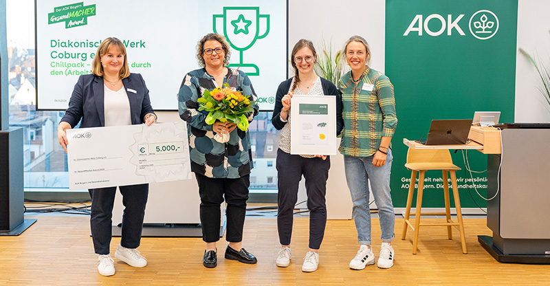 Preisverleihung „GesundMACHER Award“: Eine Gruppe von Frauen präsentiert einen Gewinnerscheck Preisverleihung „GesundMACHER Award“: Eine Gruppe von Frauen präsentiert einen Gewinnerscheck