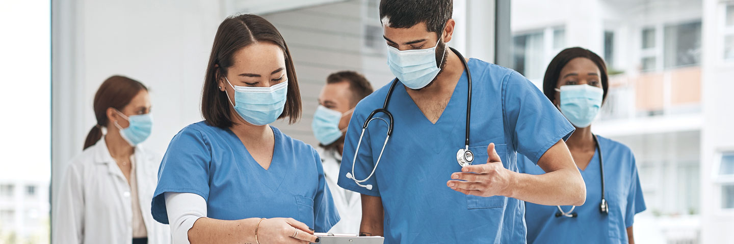 Ein Pflegeteam mit Masken im Gespräch.