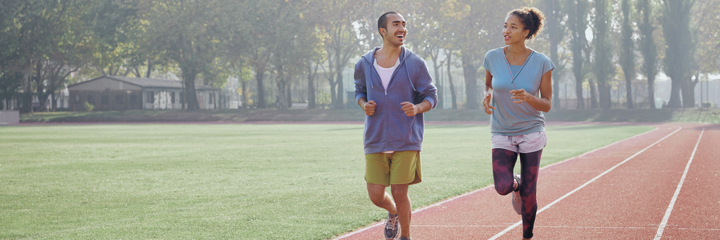 Zwei Jogger auf dem Sportplatz.