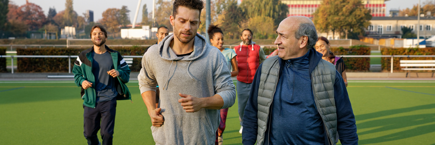 Laufgruppe trainiert auf einem Sportplatz.