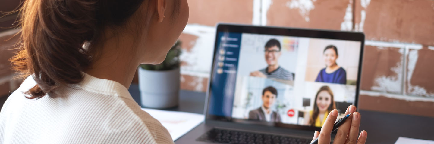 Frau im Büro nimmt an einer Onlinekonferenz mit vier Kollegen teil. 