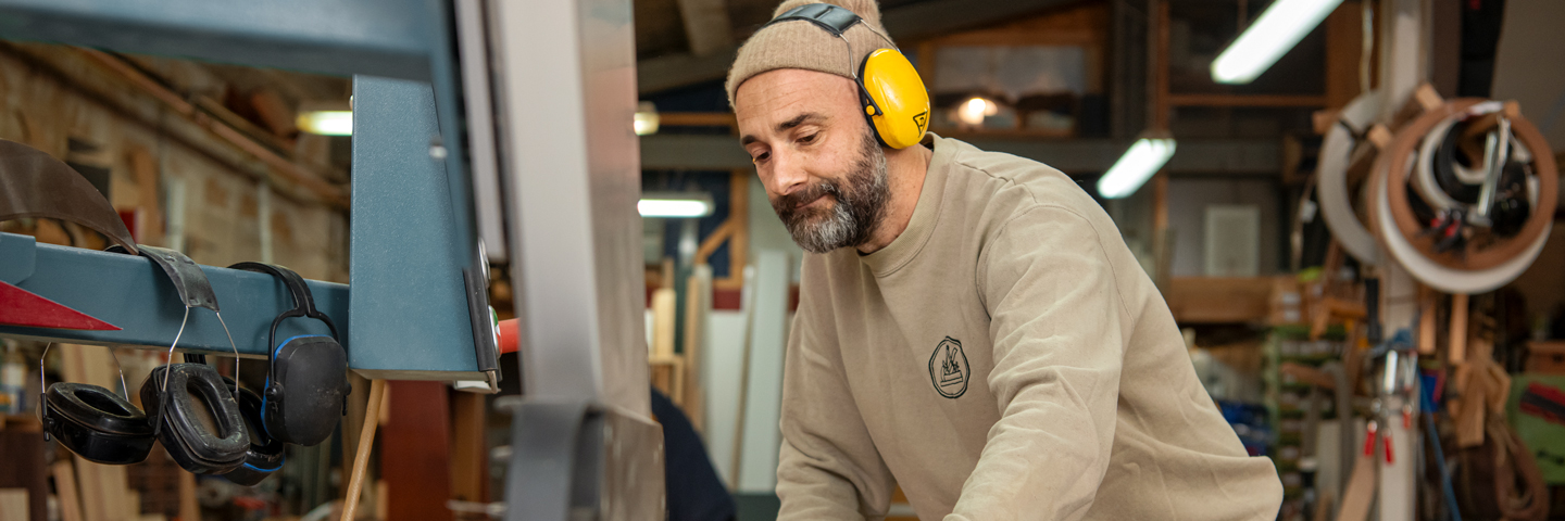 Mann mit Kopfhörern für den Gehörschutz bei der Arbeit.