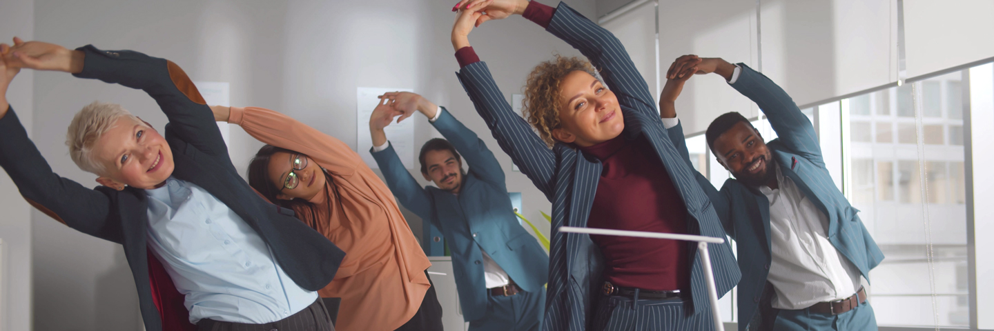 Ein Arbeitsteam macht Gymnastik im Büro.