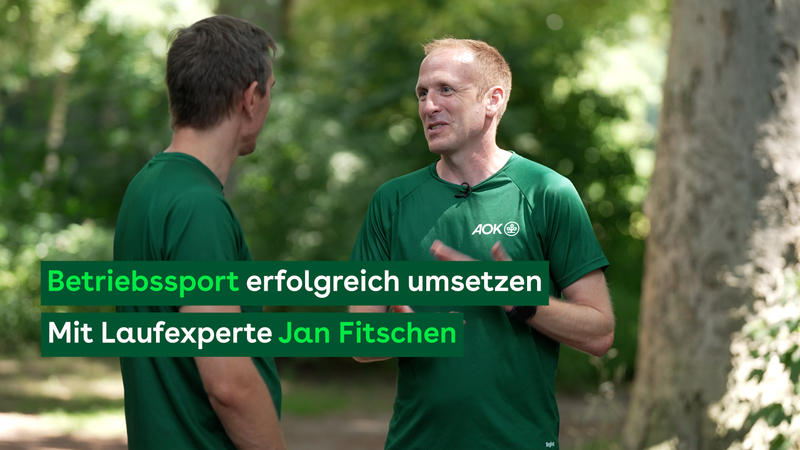 Betriebssport fördert und verbindet: Zwei Männer im Gespräch beim Joggen im Wald